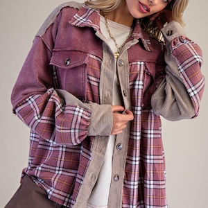 Puede incluir: Una camisa abotonada burdeos y a cuadros con detalles de pana y cuadros. La camisa tiene dos bolsillos delanteros y puños abotonados. Las mangas tienen un estampado de cuadros y el cuerpo es de color burdeos liso. La camisa es de estilo casual.