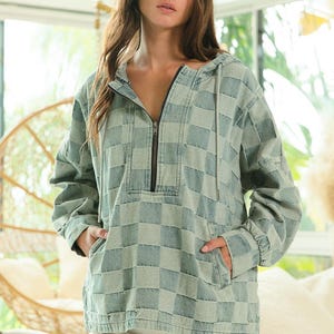 Checkered denim hoodie in faded blue and gray tones, half-zip pullover with drawstring hood and kangaroo pocket. Styled with frayed white shorts for a nostalgic Y2K vibe. Perfect for throwback fashion lovers, early 2000s aesthetic, and retro denim layering. Great for pairing with chunky sneakers, butterfly clips, and vintage accessories.