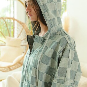 Soft denim hoodie with checkered pattern in calming blue and gray hues. Half-zip pullover with drawstring hood and kangaroo pocket—ideal for cozy loungewear, casual layering, or work-from-home outfits. Styled with frayed shorts for a relaxed, comfy vibe. Keywords: soft hoodie, cozy pullover, casual denim, slow fashion, comfort-first style.