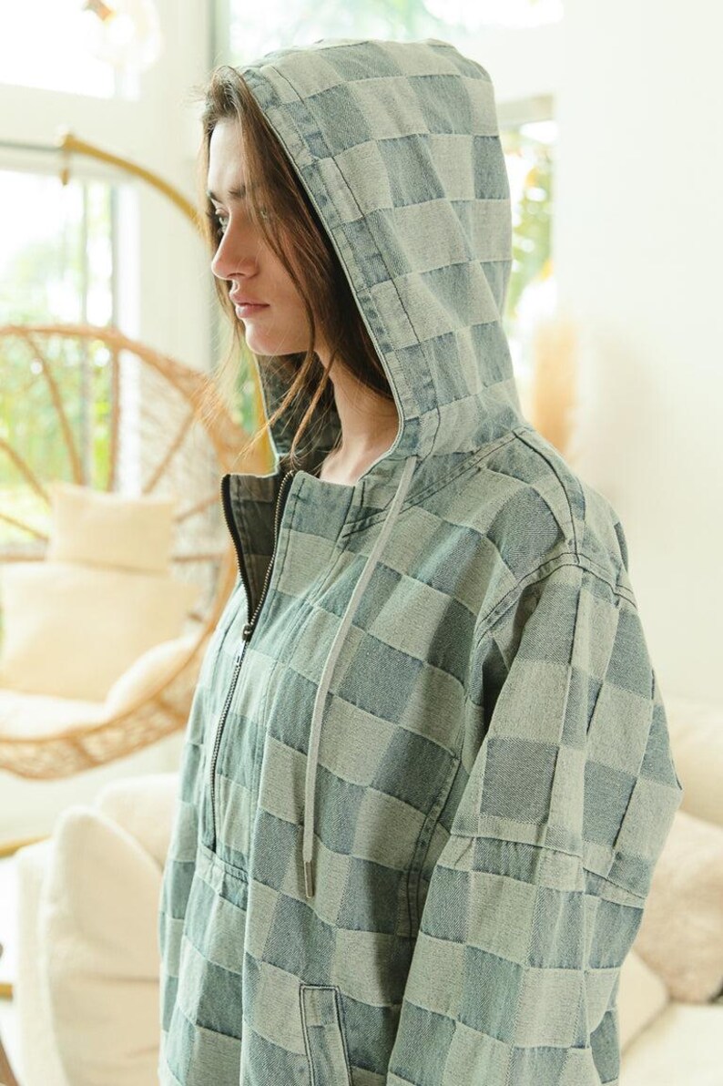 Soft denim hoodie with checkered pattern in calming blue and gray hues. Half-zip pullover with drawstring hood and kangaroo pocket—ideal for cozy loungewear, casual layering, or work-from-home outfits. Styled with frayed shorts for a relaxed, comfy vibe. Keywords: soft hoodie, cozy pullover, casual denim, slow fashion, comfort-first style.