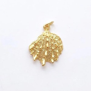 Könnte beinhalten: Ein goldfarbener Muschel-Anhänger mit strukturierter Oberfläche und einer kleinen Schlaufe für eine Kette. Der Anhänger ist eine detaillierte Darstellung einer Muschel, ideal für Schmuck mit Strandmotiven.