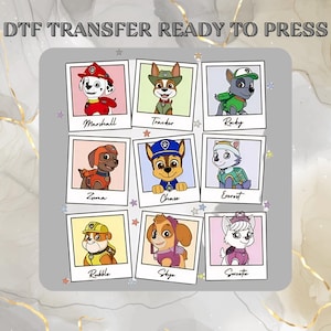 May include: DTF transfer featuring nine cartoon dog characters in individual photo frames. The characters include Marshall, Tracker, Rocky, Zuma, Chase, Everest, Rubble, Skye, and Sweetie. The text "DTF TRANSFER READY TO PRESS" is at the top.