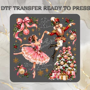 May include: A DTF transfer ready to press featuring a nutcracker and a ballerina in a pink tutu dancing. The design includes a decorated Christmas tree, gift boxes, ornaments, and the text: it's the most wonderful time of the year.