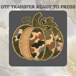 May include: A DTF transfer ready to press featuring a pumpkin graphic with a camouflage pattern in shades of green, brown, and tan. The pumpkin has a dark green stem, a single leaf, and curly vines, all outlined with a frayed, gold-colored border.