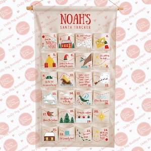 May include: A cream-coloured fabric wall hanging featuring a Santa tracker with twenty-four numbered pockets. The text reads Noah's Santa Tracker, with various Christmas-themed illustrations and phrases printed on each individual pocket square.