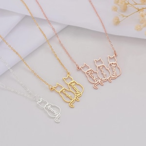 May include: A collection of personalized cat-shaped necklaces in silver, gold, and rose gold. Each necklace features a delicate chain and a cat silhouette with a name engraved on the body. The names include "Penny", "Pumpkin", "Rustie", and "Terry".