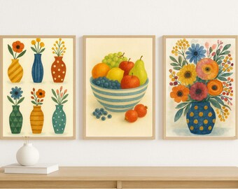 May include: Three framed art prints featuring watercolor illustrations. One print shows vases with flowers, another a bowl of fruit, and the third a bouquet of flowers in a vase. The artwork has a warm color palette.