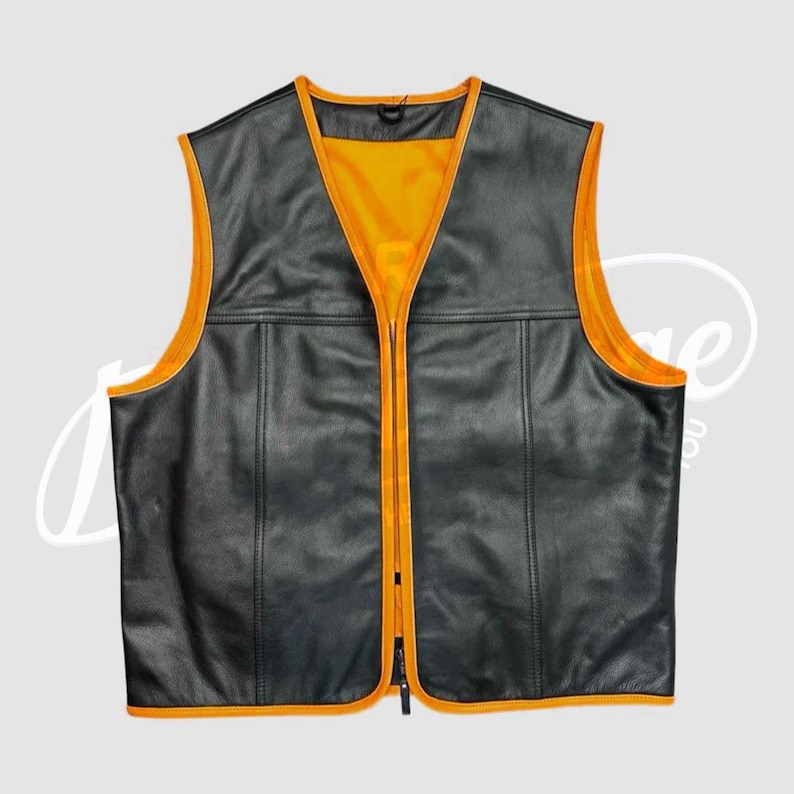 May include: Black leather vest with a bright orange interior and trim. The vest has a V-neck, a full-length zipper, and two horizontal seams across the front. The vest is sleeveless and has a classic biker style.