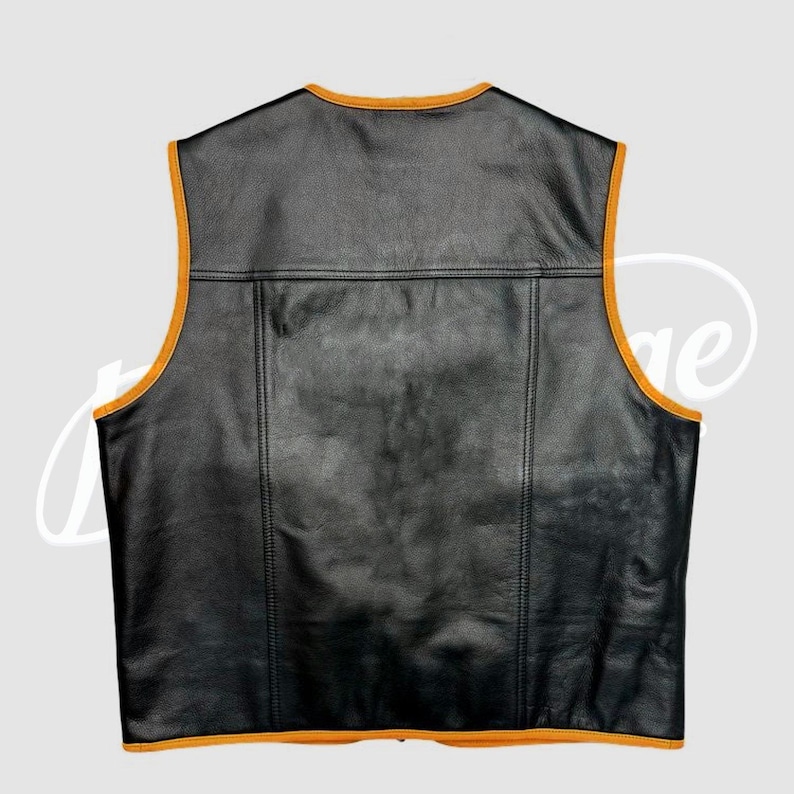 May include: Black leather vest with orange trim. The vest has a classic design with a V-neck and a rectangular panel across the upper back. The edges are trimmed with a contrasting orange color, adding a pop of color to the garment.