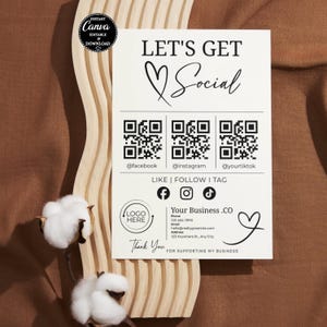May include: A white business card with the text "LET'S GET Social" and social media QR codes. The card includes social media icons for Facebook, Instagram, and TikTok. The card also has a space for a logo and contact information.