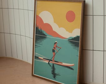May include: A framed art print depicts a person paddleboarding on a lake. The artwork features a vibrant color palette with a yellow sky, orange sun, and teal water. The person is wearing a white hat and black shorts. The frame is brown.