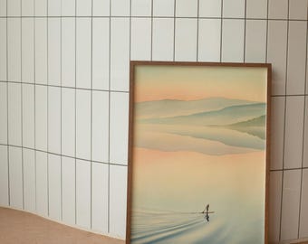 May include: A framed landscape art print featuring a serene lake scene with mountains in the background. The artwork has a warm color palette of peach, blue, and brown. A person is paddling a watercraft on the lake. The frame is made of wood.