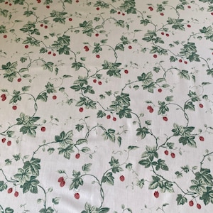 May include: White fabric with a repeating pattern of green leaves and red berries on winding vines. The design is reminiscent of a botanical illustration, creating a classic and elegant aesthetic. Ideal for home decor or crafting projects.