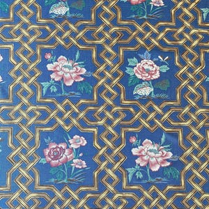 Könnte beinhalten: Blauer Stoff mit einem sich wiederholenden Muster aus rosa und roten Blumensträußen, die in goldene geometrische Gitterformen gesetzt sind. Die Blumensträuße haben grüne Blätter und Stiele. Der Hintergrund ist tiefblau.