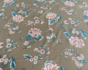 May include: Brown floral fabric with a repeating pattern of pink and blue flowers and leaves. The flowers are in various sizes and arrangements, creating a classic, vintage aesthetic. The fabric has a textured appearance.