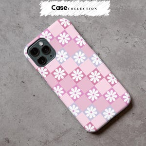 May include: A pink phone case featuring a checkerboard pattern of daisies. The design incorporates squares of light and dark pink, and lavender, with white daisies. The text "Case Collection" is at the top of the image.