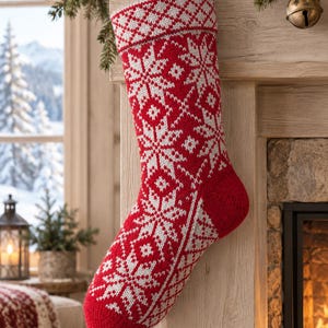May include: A red and white knitted Christmas stocking featuring a repeating snowflake and geometric diamond pattern. The stocking has a folded cuff at the top with a diamond motif and a solid red heel and toe section, designed for hanging.