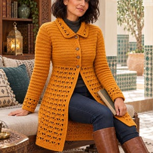May include: A mustard yellow long-sleeved crochet cardigan featuring a collared neckline, four front buttons, and a repeating fan-like stitch pattern along the lower body and cuffs. The garment is worn over a dark grey turtleneck and blue jeans.