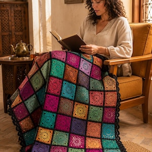 Può includere: Una coperta all'uncinetto fatta a mano con un vivace patchwork di motivi quadrati nei toni del magenta, ottanio, arancione, giallo e viola. Ogni quadrato è incorniciato da un bordo nero e la coperta è rifinita con un bordo smerlato nero.