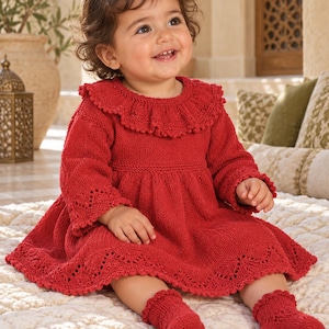 May include: A long-sleeved red knit dress featuring a ruffled collar, a gathered waist, and intricate lace-like detailing along the hem and cuffs. The garment is paired with matching red knit socks that have a delicate scalloped edge at the top.