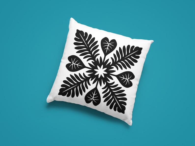 May include: White square pillow with a black floral design. The design features a central starburst surrounded by stylized leaves and heart-shaped leaves. The pillow is set against a teal background.