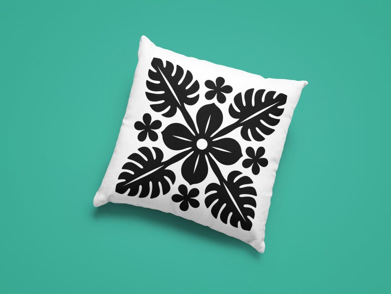 May include: White square pillow with a black floral and leaf pattern. The design features a central flower with radiating leaves and smaller flowers, set against a teal background.