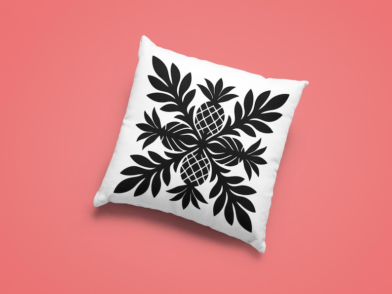 May include: Square white pillow with a black pineapple and leaf design. The design features four pineapples surrounded by leaves, creating a symmetrical pattern. The pillow is on a coral-colored background.