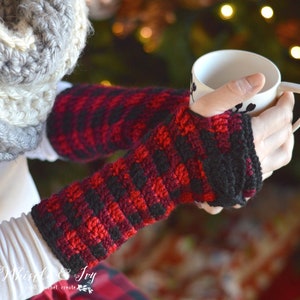 Puede incluir: Guantes sin dedos de crochet rojo y negro con un patrón de cuadros de búfalo. Los guantes los lleva una persona que sostiene una taza blanca.