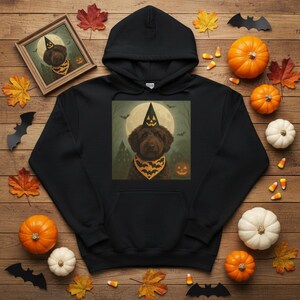 Peut inclure: Sweat à capuche noir sur le thème d'Halloween avec un chien portant un chapeau de sorcière et un bandana à motifs de chauve-souris. Le motif est placé devant une pleine lune et un arrière-plan effrayant. Le sweat à capuche est entouré de citrouilles, de feuilles et de décorations d'Halloween.