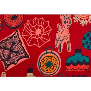 May include: Red fabric with a repeating pattern of Christmas ornaments, a deer, and snowflakes. The ornaments are in various shapes and colors, including teal, orange, and yellow. The deer is pink with black outlines.