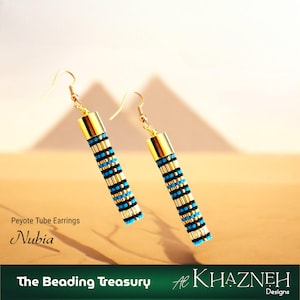 Peut inclure: Boucles d'oreilles tubulaires Peyote avec des accents dorés et un motif de perles bleues, noires et dorées. Les boucles d'oreilles sont suspendues à des crochets d'oreilles dorés. Le mot "Nubia" est imprimé sur l'image.