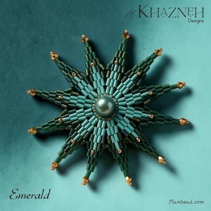 Puede incluir: Un broche en forma de estrella hecho de cuentas de color verde oscuro y azul verdoso, con una cuenta central lisa similar a una perla y pequeños detalles dorados en las puntas. El texto "Al Khazneh Designs" y "Emerald" es visible.