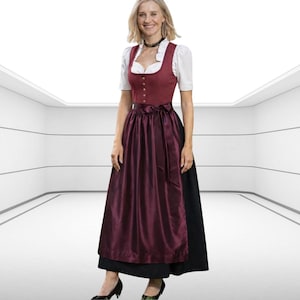 Puede incluir: Un vestido dirndl burdeos tradicional con una blusa blanca y una falda negra. El vestido presenta un corpiño ajustado con botones decorativos y un delantal de satén. El atuendo se completa con tacones negros.