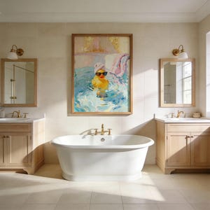 May include: A bathroom scene featuring a white, freestanding bathtub and two wooden vanities with mirrors. A framed painting of a yellow rubber duck wearing sunglasses and a towel on its head hangs above the tub. The room has neutral-toned tiles and gold fixtures.