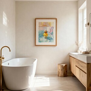 May include: A bathroom scene featuring a framed artwork of a yellow rubber duck wearing sunglasses in a pool. The bathroom has a white bathtub, a wooden vanity, and a wooden stool. The walls are a neutral color, and the room is well-lit.