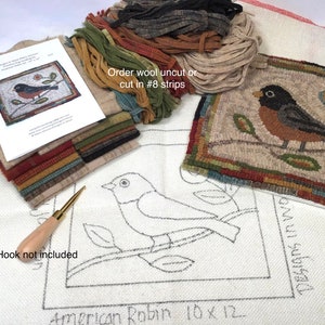 May include: A rug hooking kit featuring an American Robin design. The kit includes wool strips in various colors, a printed pattern, and a finished example. The text on the pattern reads "American Robin 10 x 12". The hook is not included.