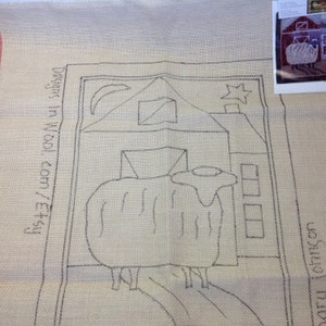 May include: A beige rug hooking pattern featuring a sheep in front of a barn, with a moon and star in the sky. The design is outlined in black ink. Text on the left side reads "designs in wool.com/etsy".
