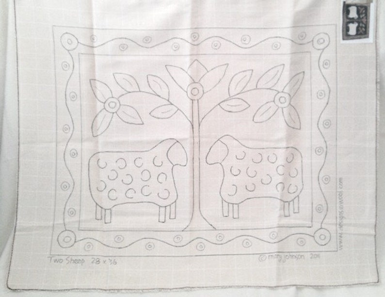 K&ouml;nnte beinhalten: Beige Stoffpaneel mit handgezeichnetem Design von zwei Schafen und einem Baum mit Blumen, umrahmt von einem dekorativen Rand. Der Text "Two Sheep 71 x 91 cm" befindet sich unten, mit der Signatur des K&uuml;nstlers.