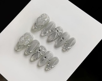 Unghie finte cromate argento, nail art 3D con fiocco, cuore e spirale, unghie finte a stiletto trasparenti argento effetto specchio di lusso, set riutilizzabile e glamour