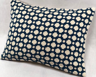 May include: A rectangular throw pillow with a navy blue and white geometric pattern. The pillow is made of a soft, textured fabric.