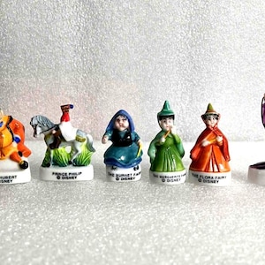 Puede incluir: Una colección de siete figuras de porcelana con personajes de La Bella Durmiente de Disney. Las figuras incluyen a la Princesa Aurora, el Rey Hubert, el Príncipe Felipe a caballo, el Hada Sunset, el Hada Merryweather, el Hada Flora y Maléfica.