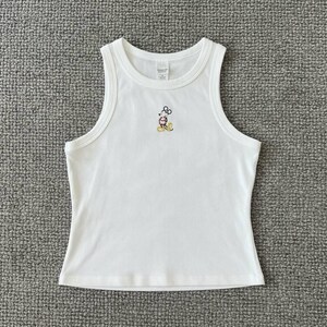 May include: White tank top with a small embroidered Mickey Mouse design. The sleeveless top has a round neckline and a fitted silhouette. The Mickey Mouse design features black, red, yellow, and white colors.