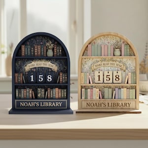 May include: Two wooden bookshelf-shaped book counters. One is navy blue, the other is natural wood. Both have shelves filled with miniature books, a banner that reads "BOOKS READ THIS YEAR", and the number "158". The bottom of each reads "NOAH'S LIBRARY".