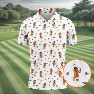 Può includere: Una polo bianca a maniche corte con un motivo ripetuto di hot dog a cartoni animati che giocano a golf. Gli hot dog indossano cappelli e occhiali da sole, tenendo mazze da golf vicino a bandiere e palline. Un inserto circolare mostra un dettaglio.