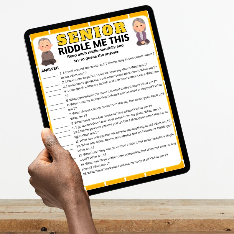 May include: A tablet displaying a "SENIOR RIDDLE ME THIS" game. The game features riddles with numbered questions and answer lines. The tablet is held by a person.