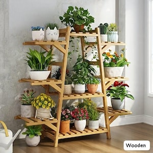 May include: A wooden plant stand with multiple shelves, displaying various potted plants. The stand is made of light-colored wood and has a ladder-like design. The plants include flowering varieties and succulents, in white, terracotta, and decorative pots. The word "Wooden" is visible.