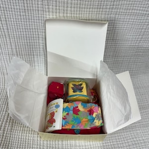 May include: A set of three ceramic mugs with a speckled, matte finish. The mugs are in shades of cream, light gray, and dark gray. Each mug has a simple, minimalist design, perfect for coffee or tea.