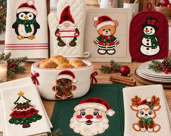 May include: A collection of Christmas kitchen textiles including a tea towel with a penguin, an oven mitt with a gnome, a potholder with a snowman, a fabric basket with a gingerbread man, and towels featuring a tree, Santa, and a reindeer.