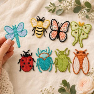 Puede incluir: Una colección de ocho parches bordados de insectos que incluye una libélula azul, una abeja amarilla y negra, una mariposa rosa con estampado floral, una polilla verde claro, una mariquita roja, un escarabajo turquesa, un escarabajo verde lima y una cigarra naranja.