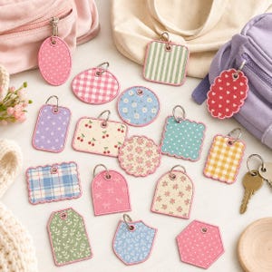 May include: A collection of various fabric keychains in diverse shapes including circles, squares, rectangles, and hexagons, featuring patterns like gingham, stripes, polka dots, cherries, and floral prints, each attached to a metal split ring.